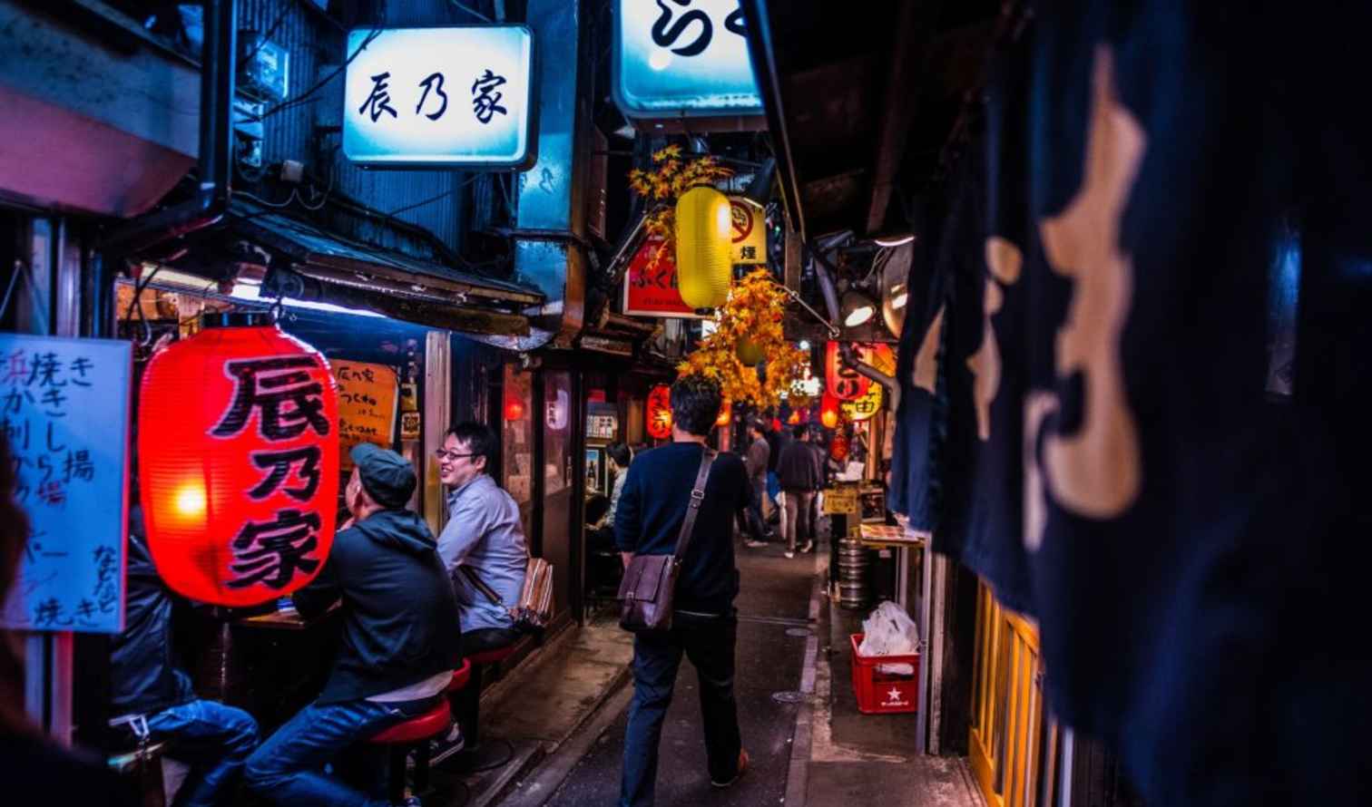 People walking through Omoide Yokocho alley in Shinjuku, Tokyo.