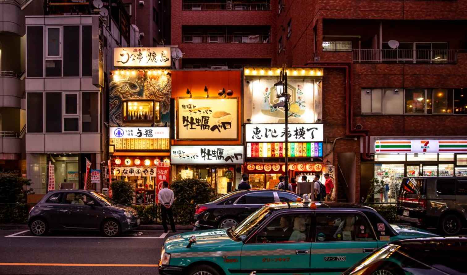 Street view of Ebisubashi Yokocho with illuminated restaurant signs in Tokyo.