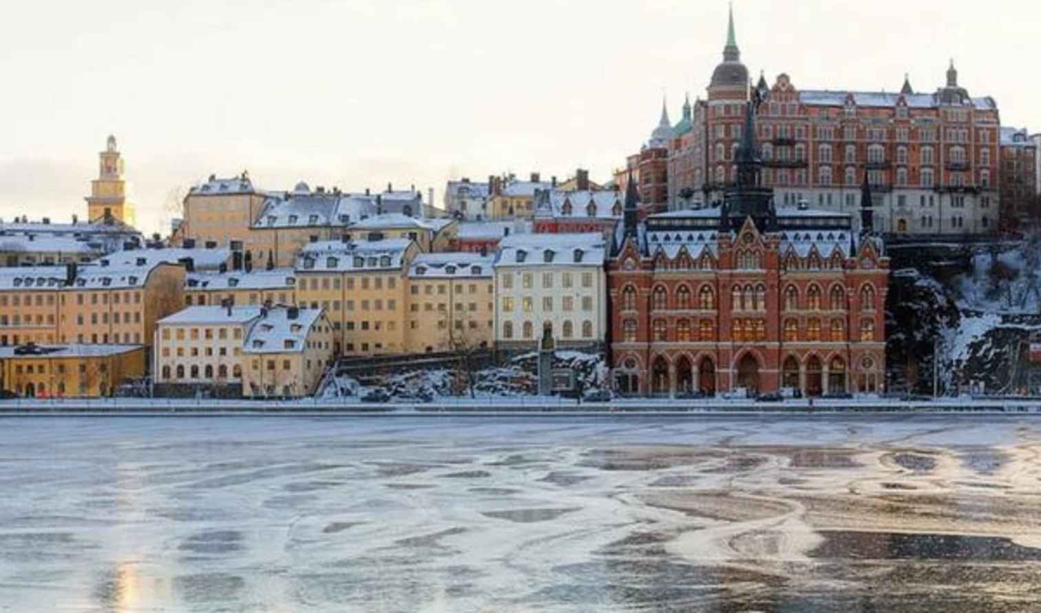 View of Sodermalm district buildings by frozen water, Stockholm.