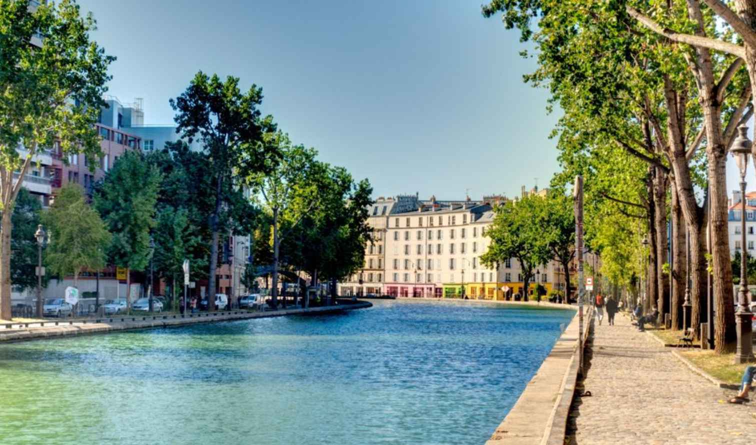People walking along the Canal Saint-Martin path in Paris.
