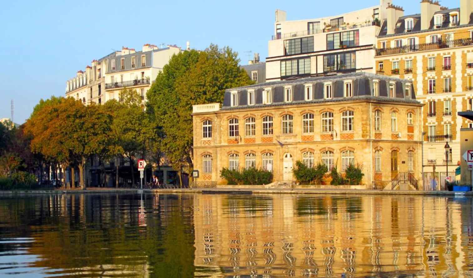 Building reflected in water at Canal Saint-Martin, Paris.