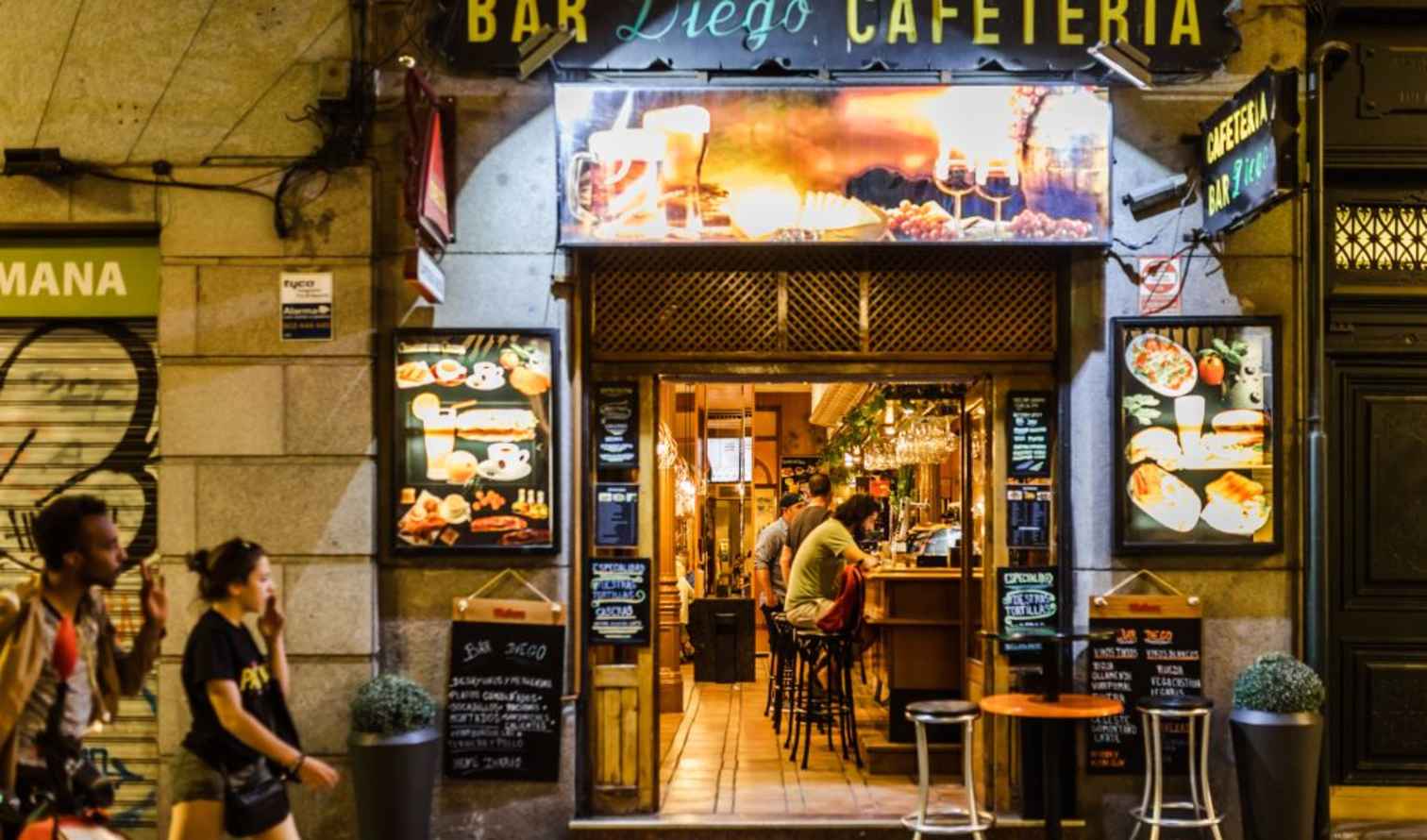 People seated at a counter inside Bar Diego Cafeteria in Madrid