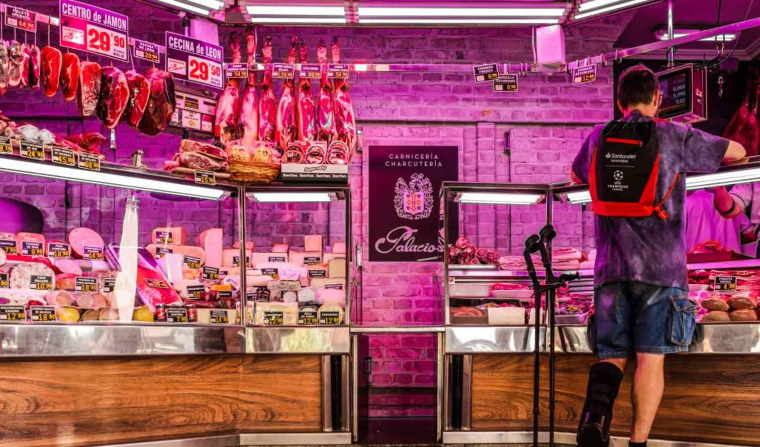 A person shopping at a meat counter in a charcuterie shop in Madrid
