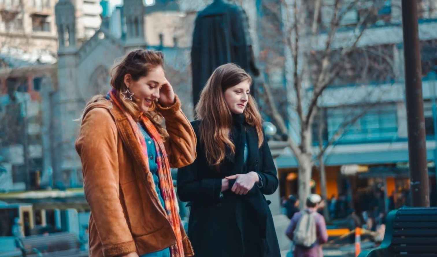 Two women walking near the church in Melbourne's Federation Square.