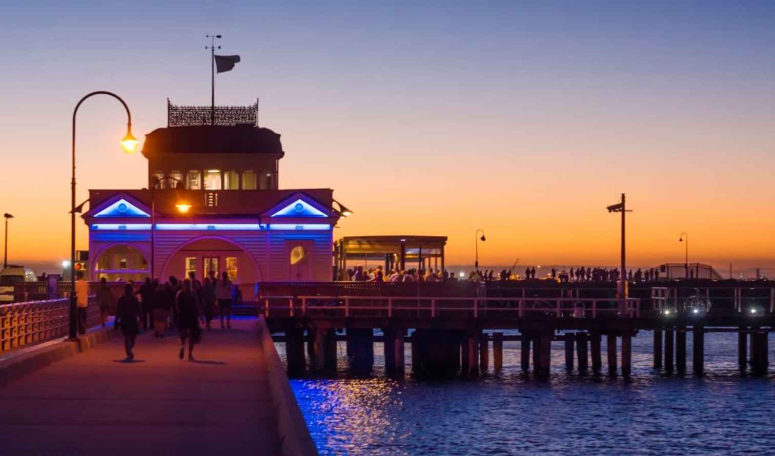 St Kilda Pier at sunset with silhouetted people on the walkway in Melbourne