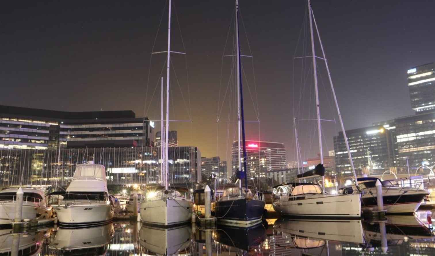 Boats docked at night in Melbourne's Docklands.