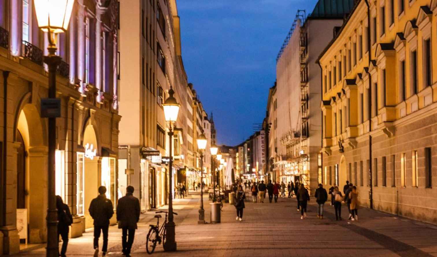 People walking on Theatinerstraße in Munich during the evening.
