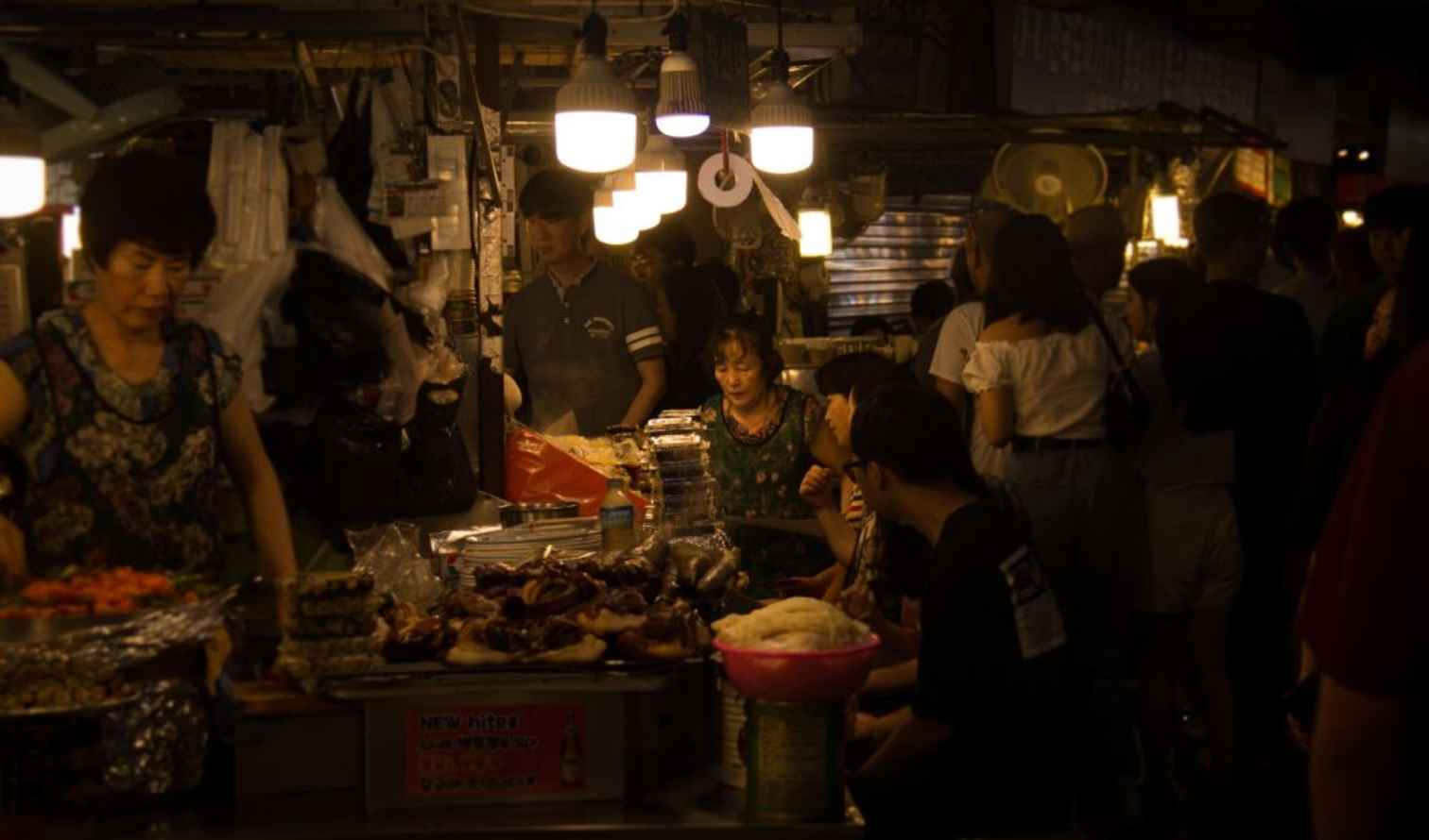 People gather at a night market food stall in Seoul