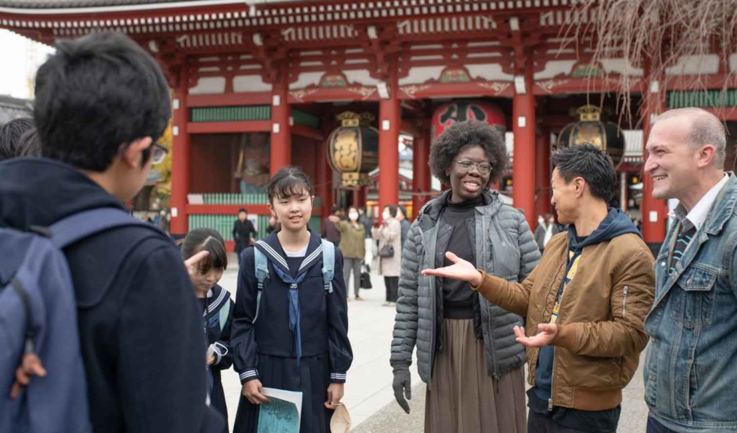 Group of people talking outside Senso-ji Temple in Tokyo.