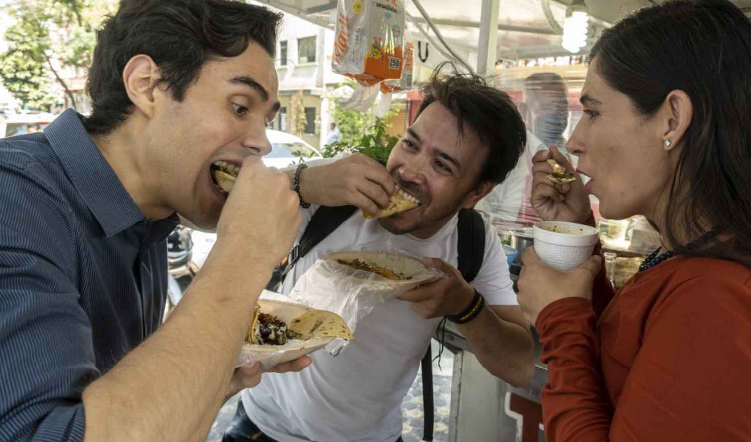 People eating tacos at a street food stand in Mexico City