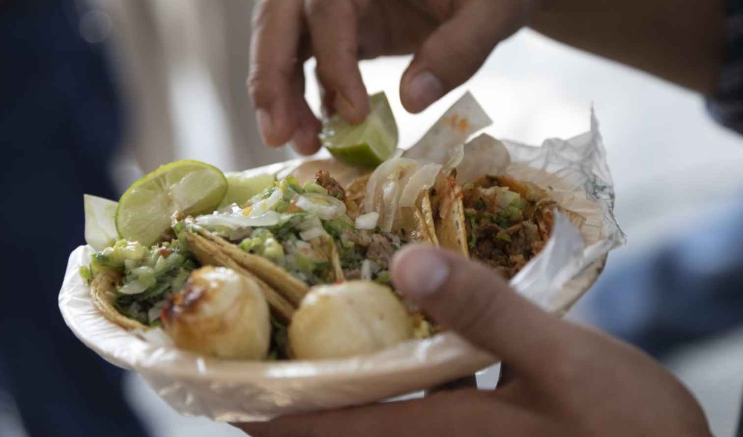 Close-up of tacos with grilled onions and lime in a paper plate in Mexico City