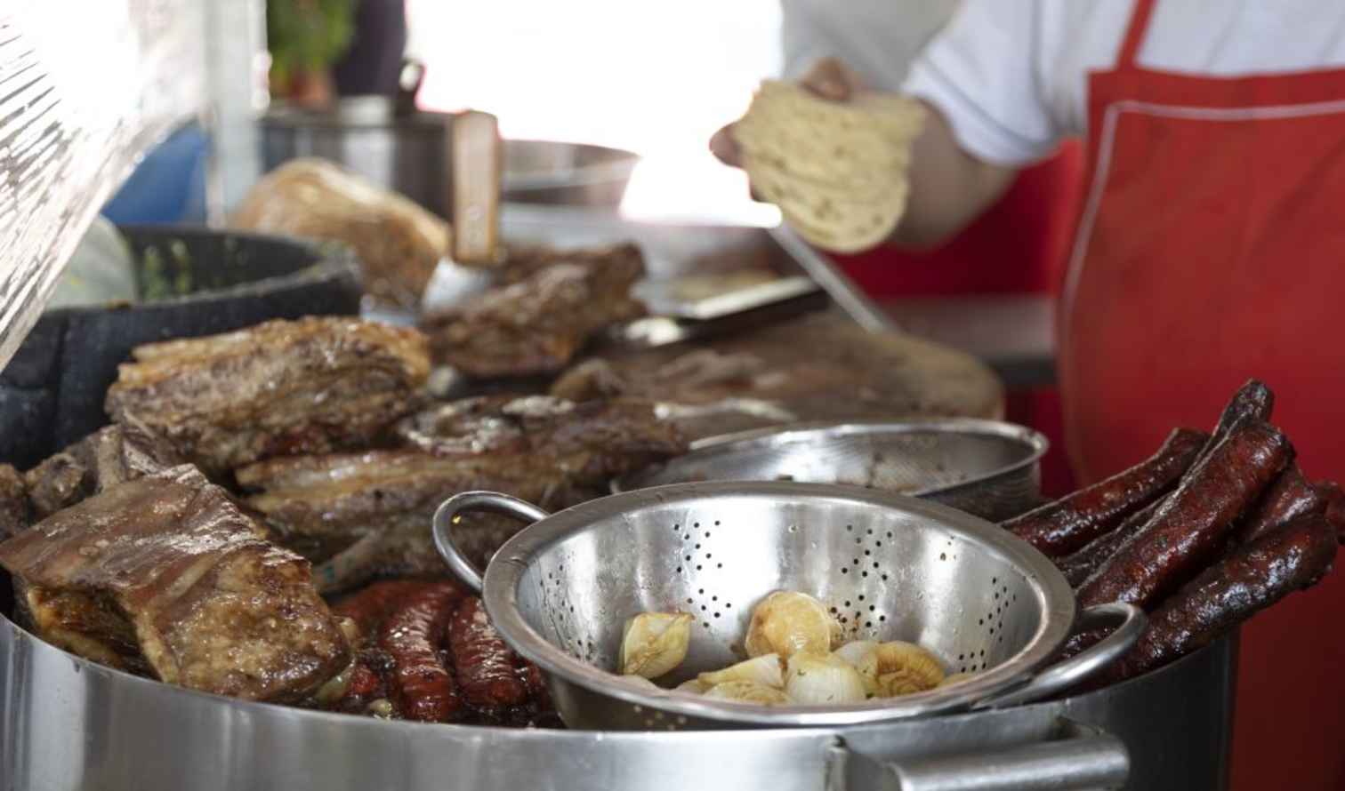 Street vendor in Mexico City preparing tacos with various meats in Mexico City
