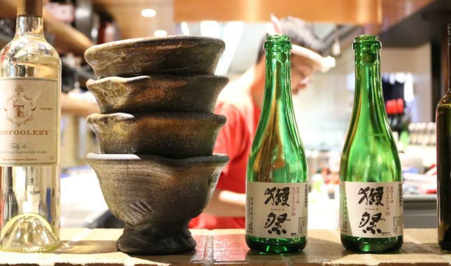 Stacked stone bowls and bottles on a restaurant counter in Tokyo