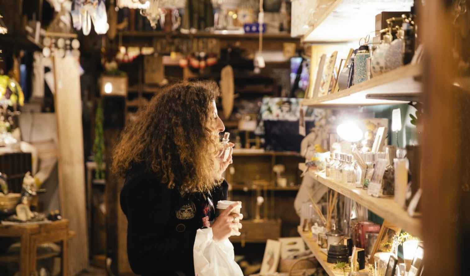 Person examining items on shelves in a rustic store interior in Tokyo