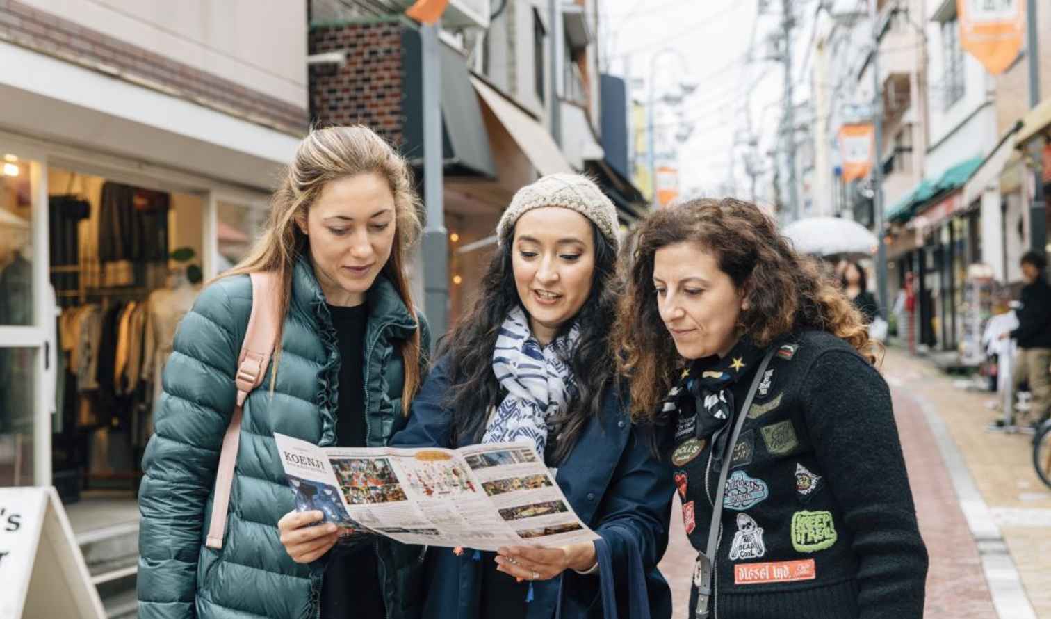 People examining a map in a busy shopping area in Tokyo