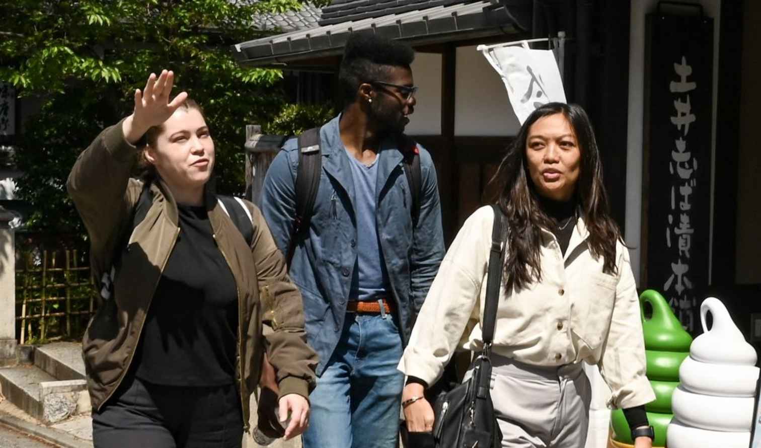 Three people walking near Kiyomizu-dera Temple in Kyoto, Japan.