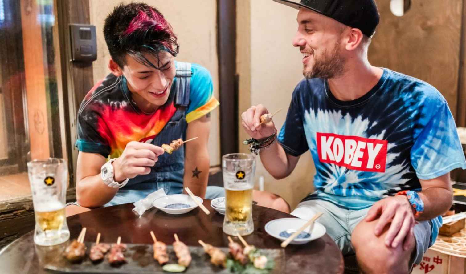 Two people eating skewers inside a Japanese restaurant in Kyoto