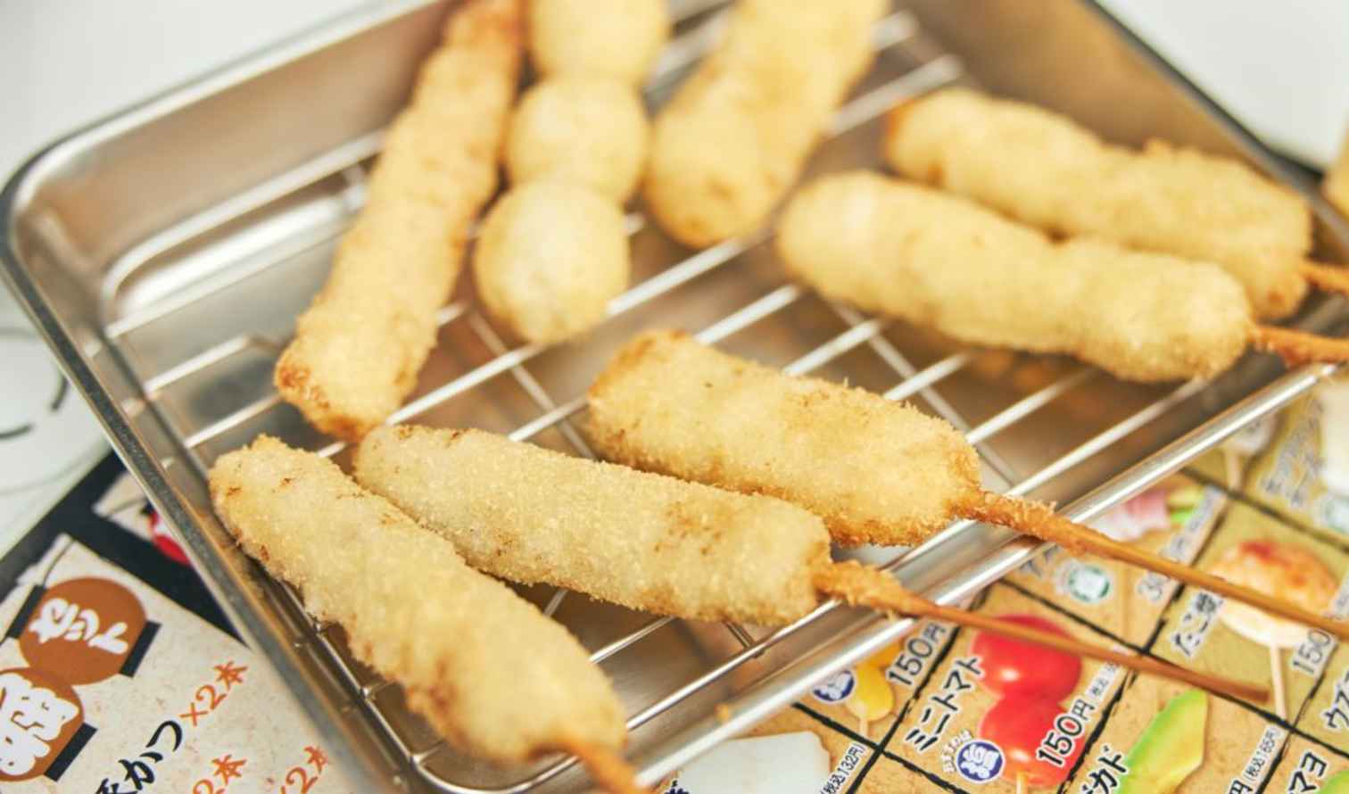 Tray of skewered fried foods on a metal rack in Osaka