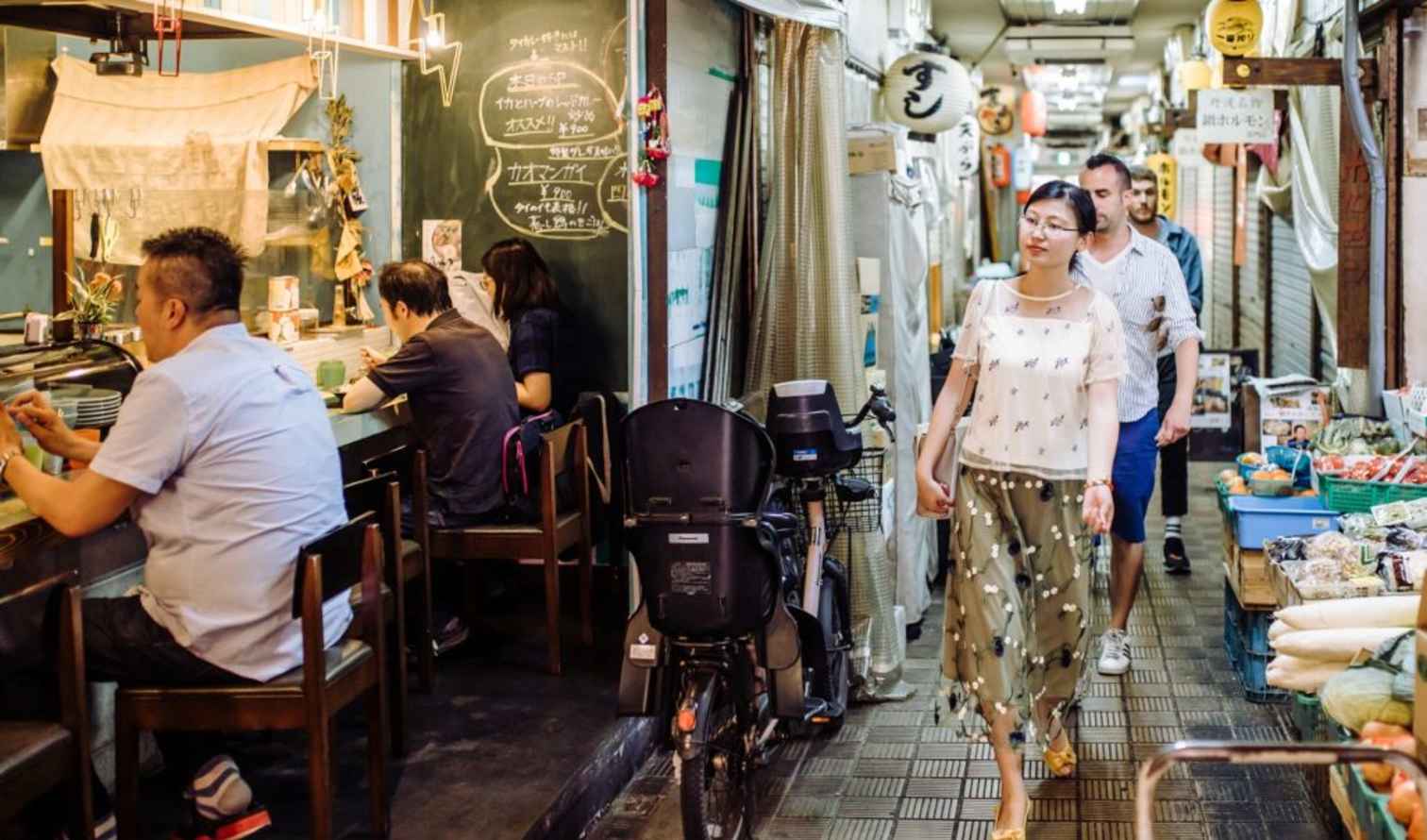 Shoppers walk through Kuromon Ichiba Market in Osaka, Japan.