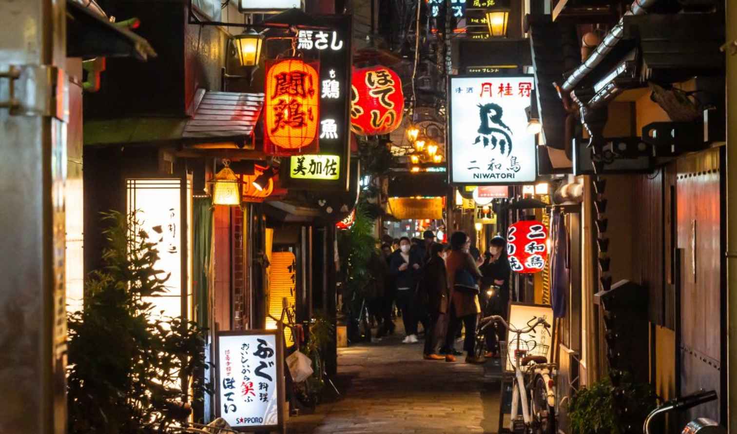 Osaka Omoide Yokocho alley with glowing restaurant signage.