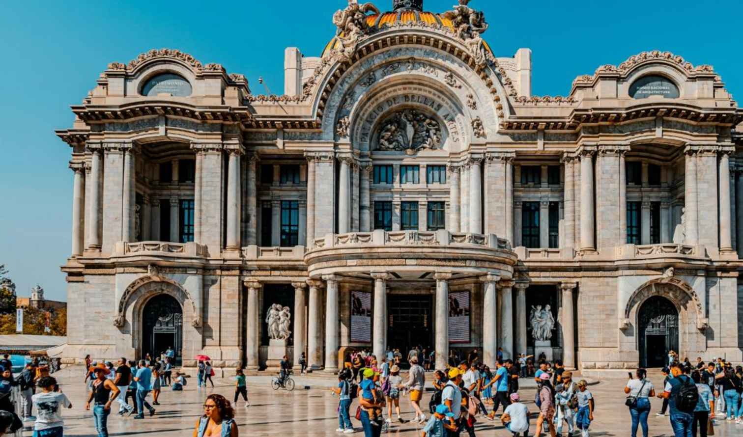 Palacio de Bellas Artes in Mexico City with people walking in front.
