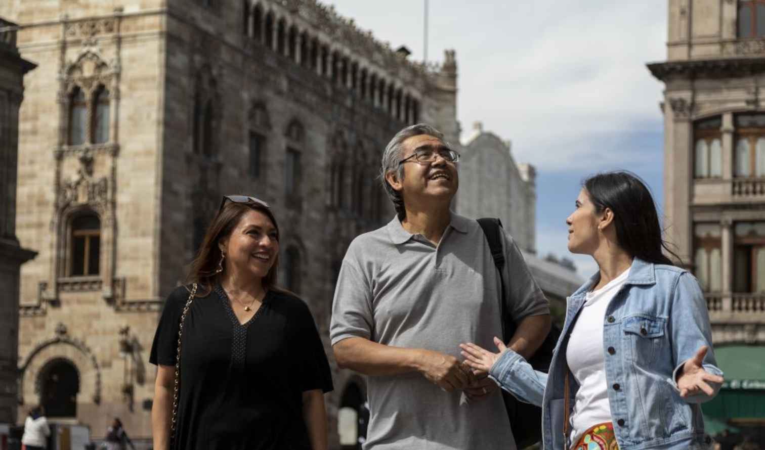 Three people walking near Hospicio Cabañas in Guadalajara, Mexico.