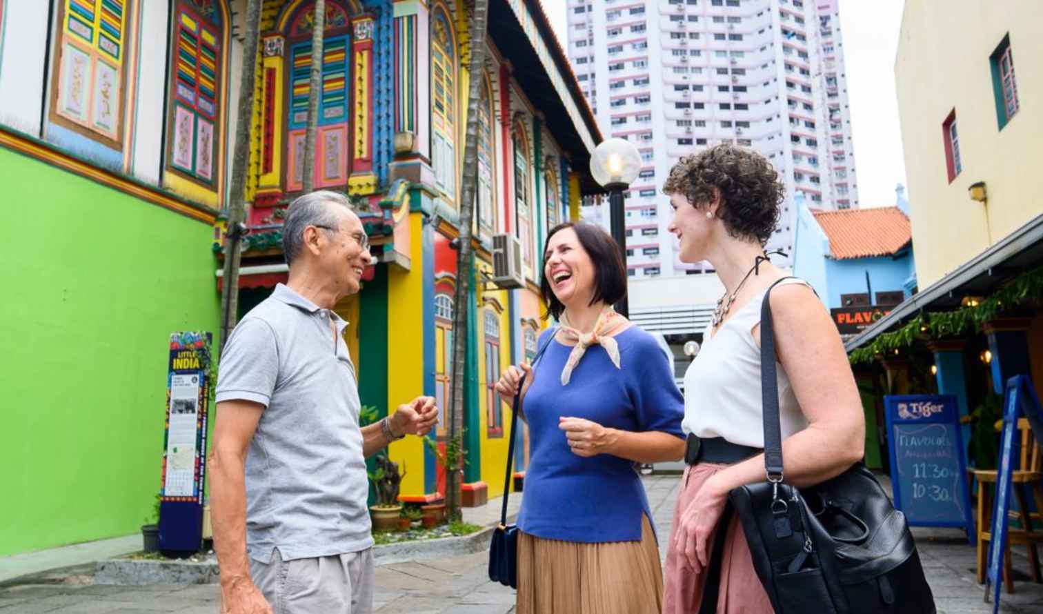 People standing near the colorful Tan Teng Niah house in Little India, Singapore.