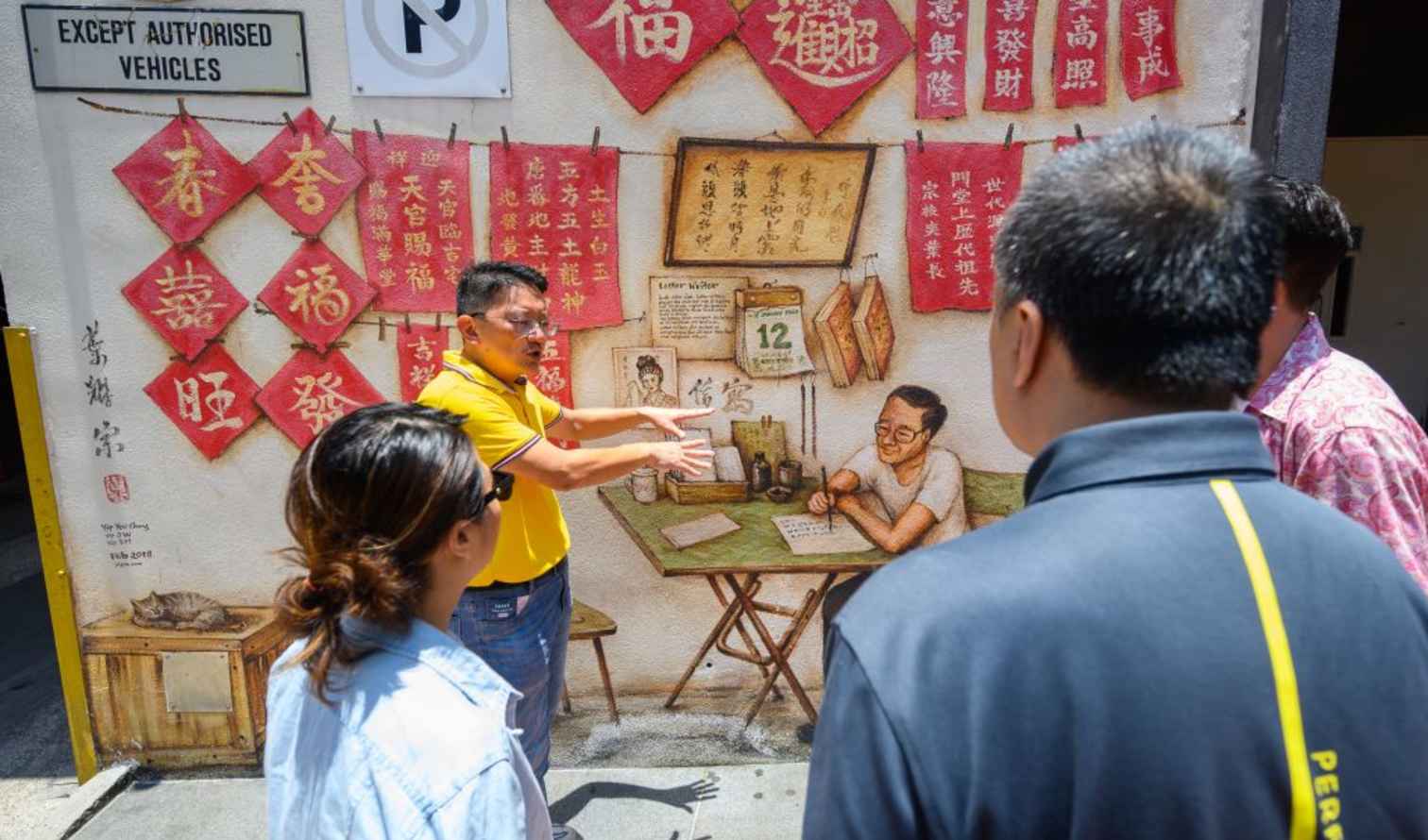 Tourist group observing mural in Chinatown, Singapore.