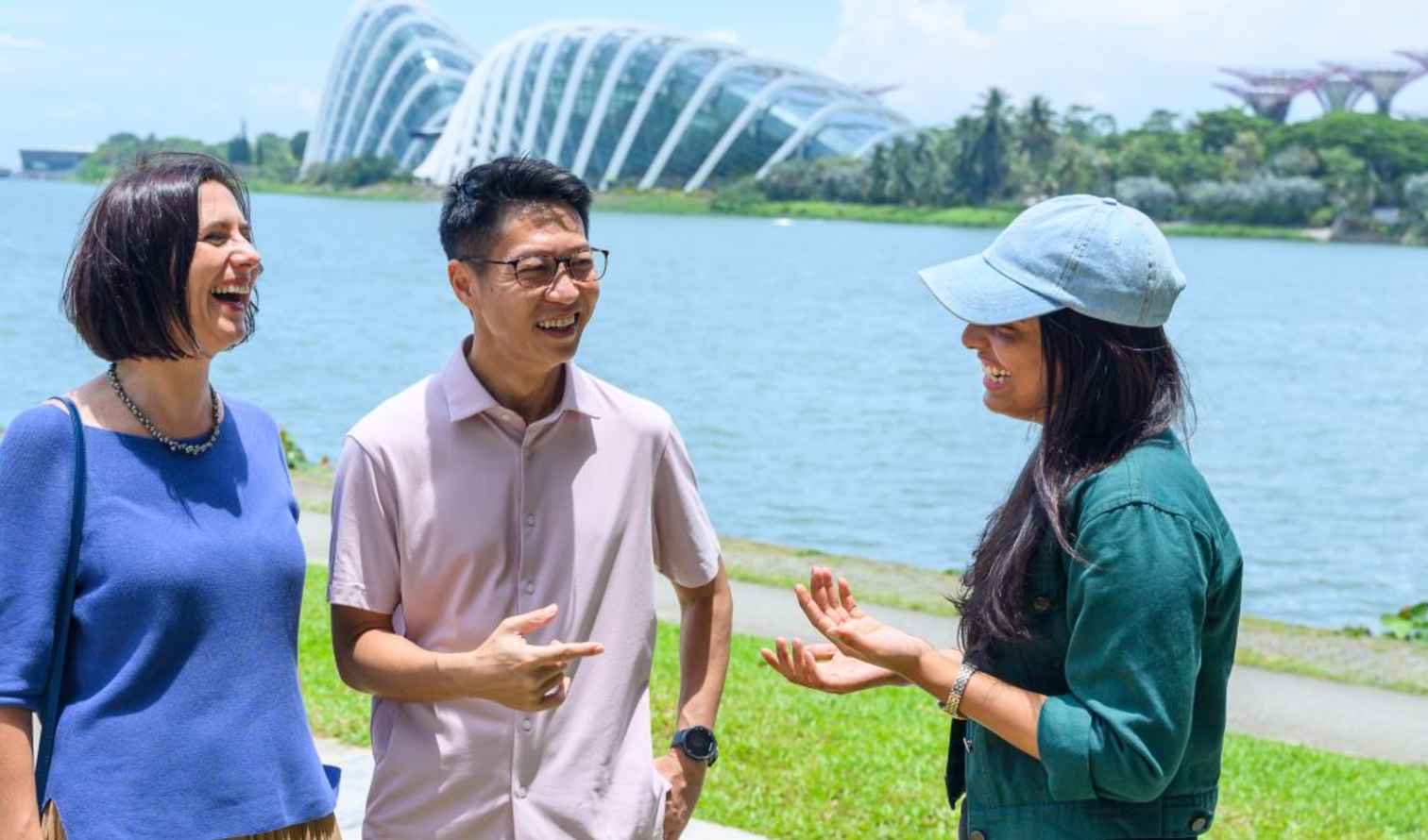 Three people talking by Marina Bay, Singapore.