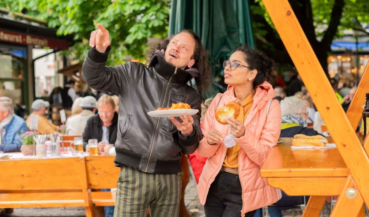 Two people at Viktualienmarkt in Munich enjoying food.
