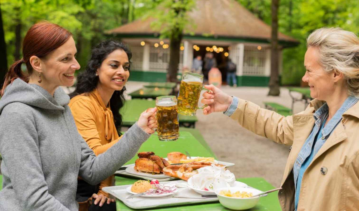 Outdoor scene of women enjoying beer and food in a park setting in Munich