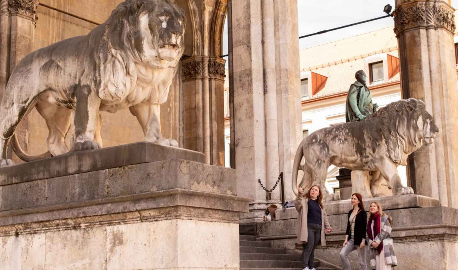 People standing near lion statues at Feldherrnhalle in Munich, Germany.