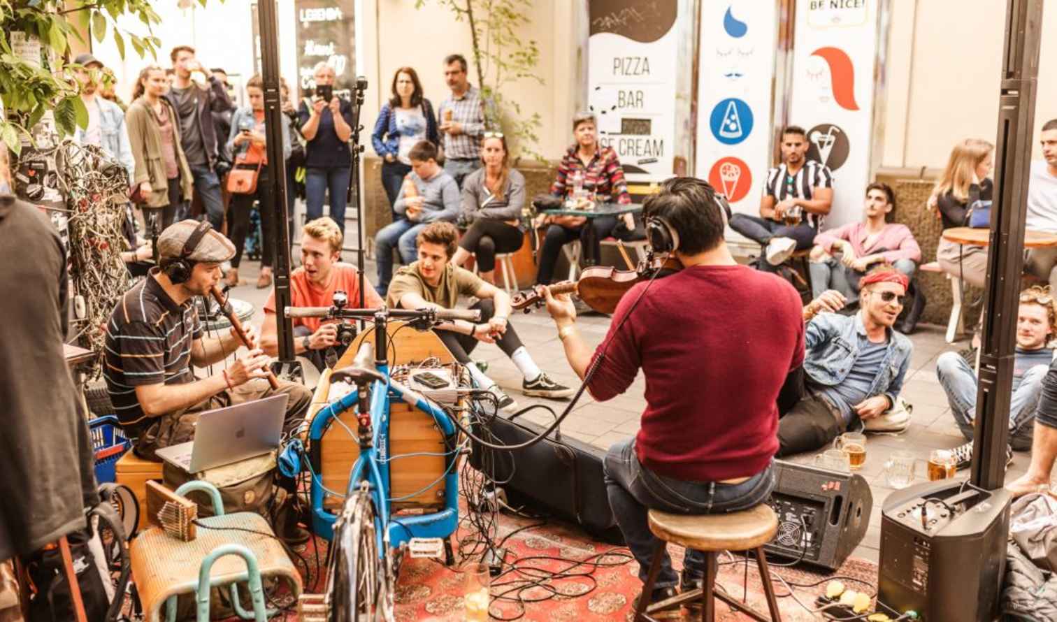 Musicians perform on a street surrounded by a crowd in Budapest