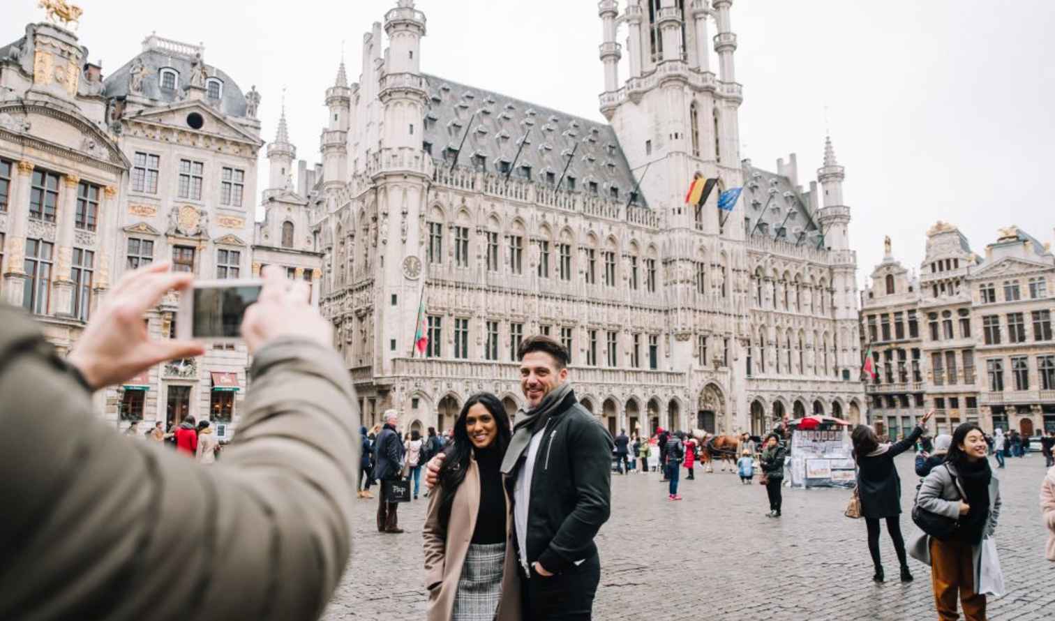 People taking pictures in front of Brussels City Hall at Grand Place.
