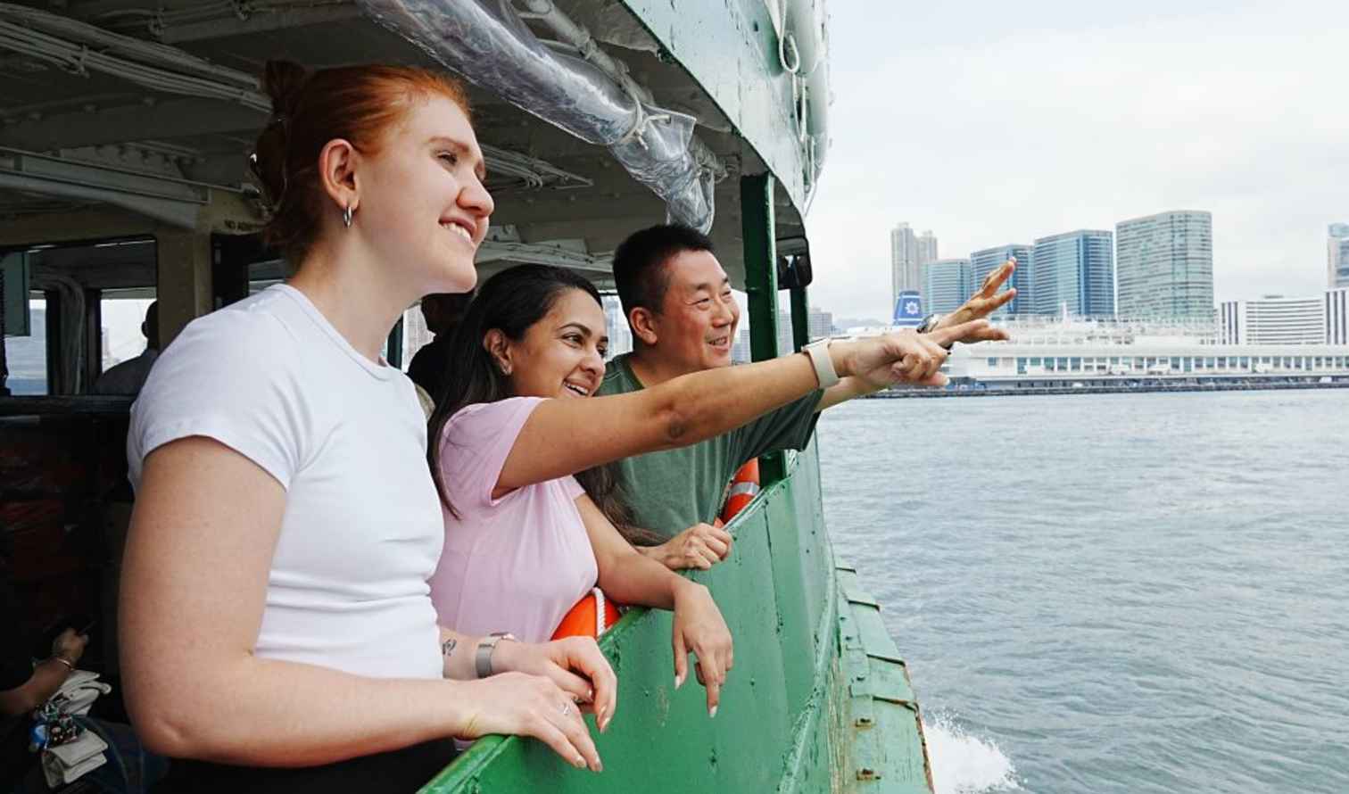 The Star Ferry sails past modern buildings in Hong Kong.