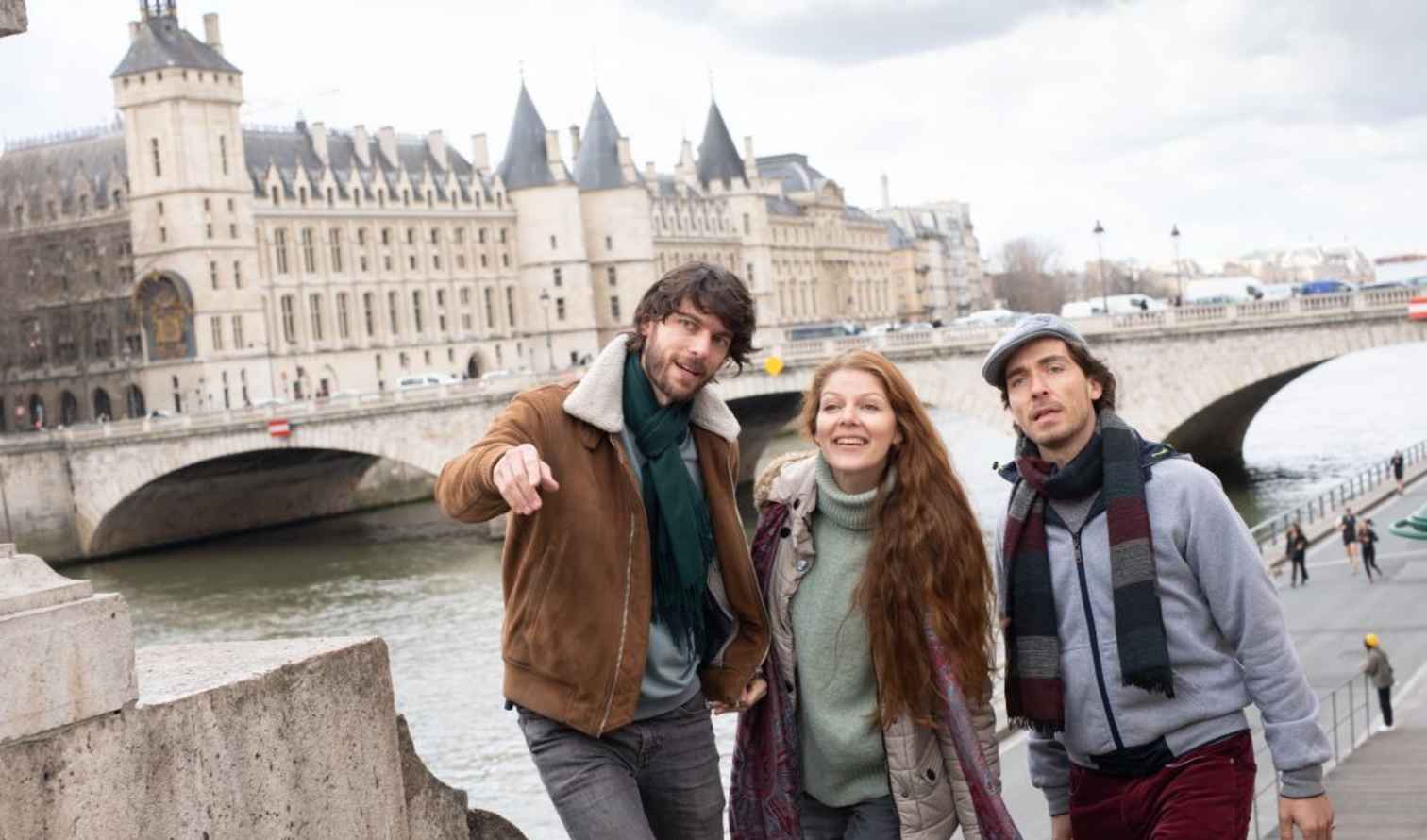 Three people standing near the Pont au Change in Paris.