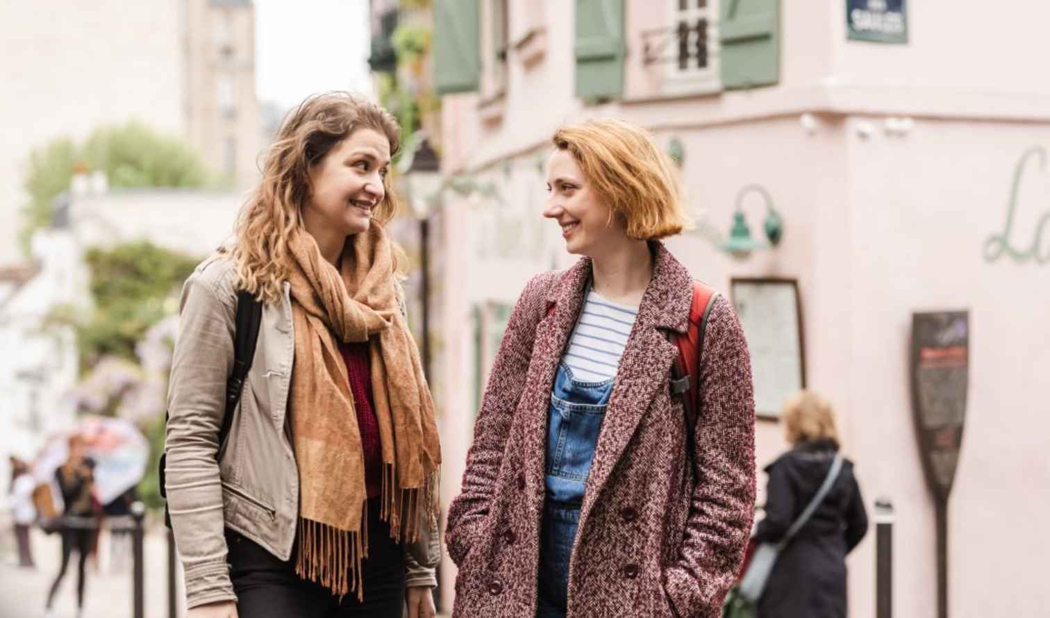 Two women talking outside La Maison Rose in Montmartre, Paris.