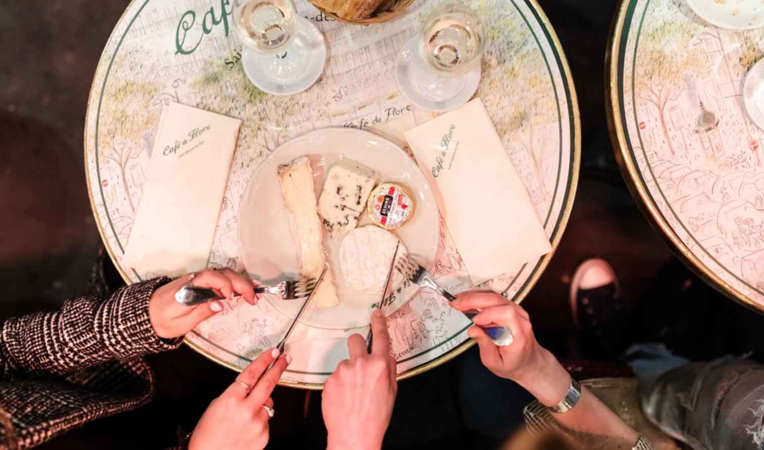 People sharing a cheese platter at Café de Flore in Paris.