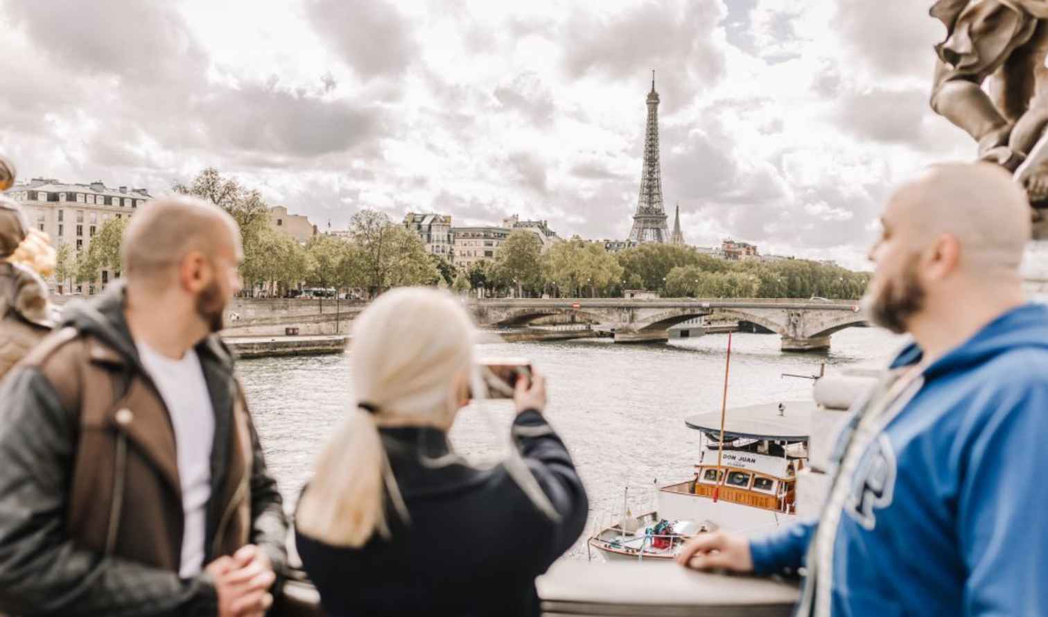 People on a bridge overlooking the Eiffel Tower in Paris.