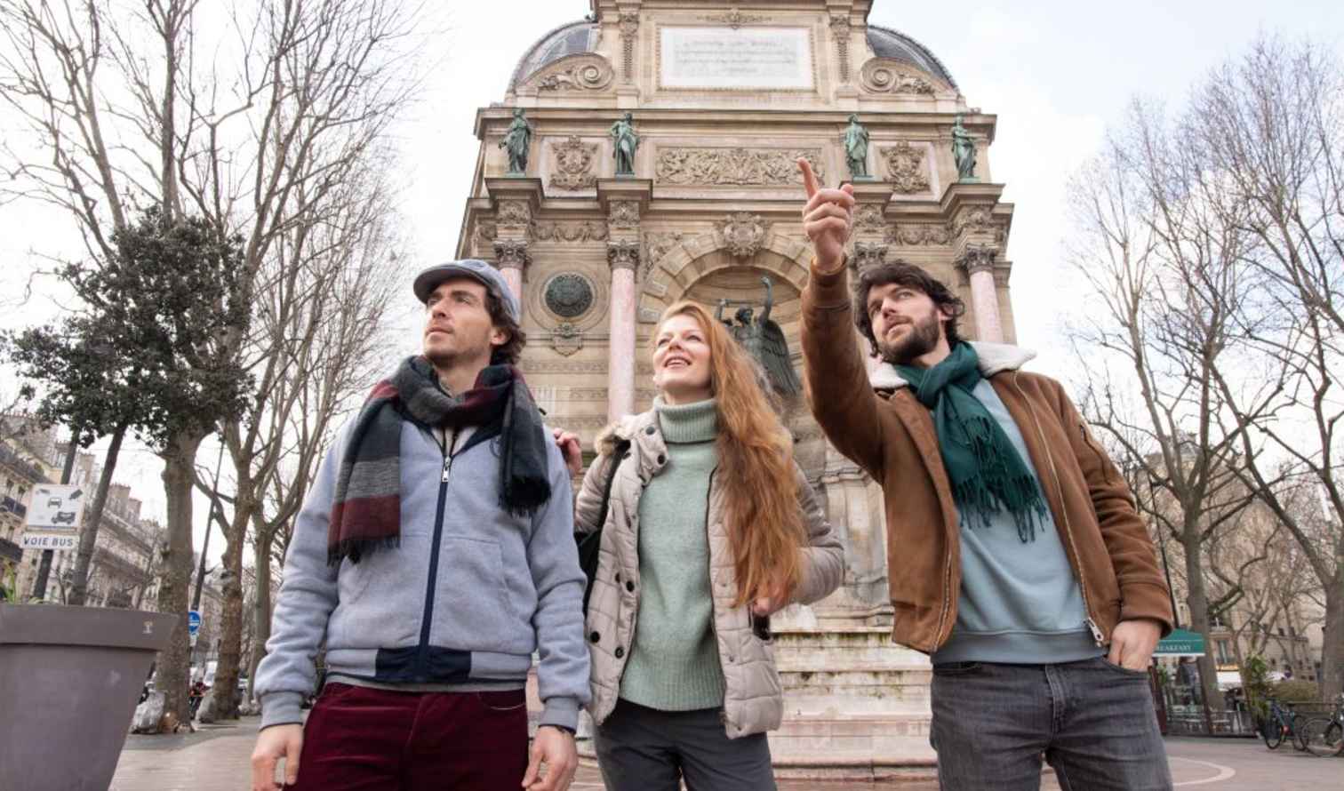 Three people standing in front of the Fontaine Saint-Michel in Paris.