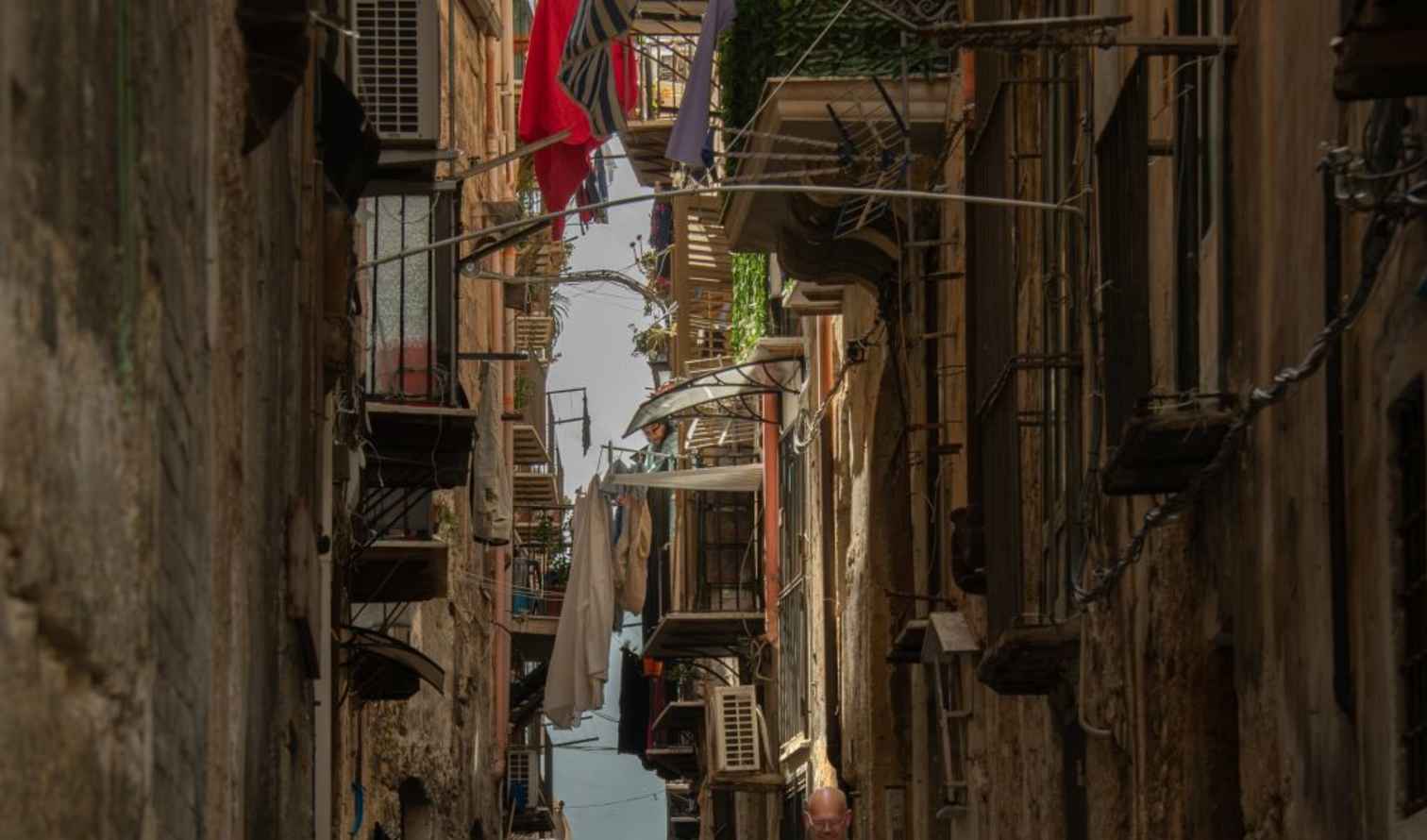 Narrow alleyway in Palermo, Italy, with overhanging laundry.