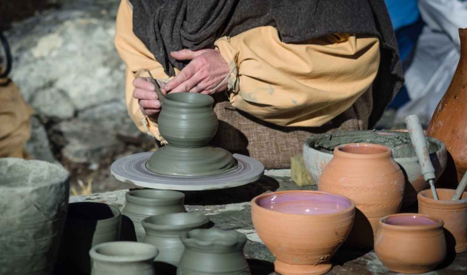 Person shaping pottery on a wheel outdoors in Verona
