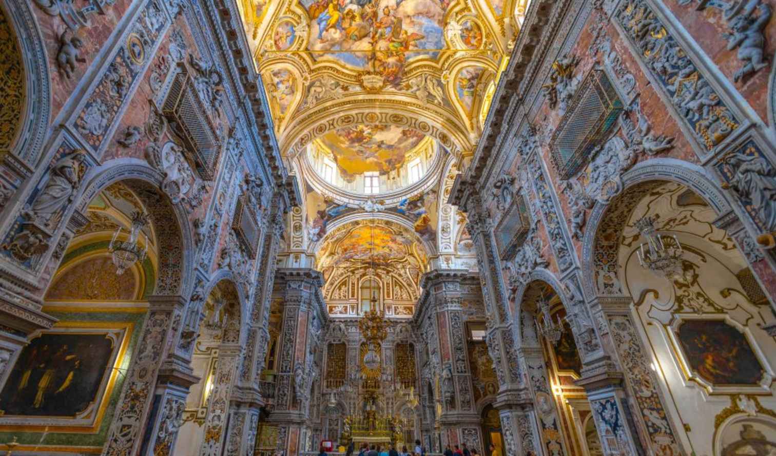 Visitors exploring the detailed architecture of La Chiesa del Gesù  in Palermo