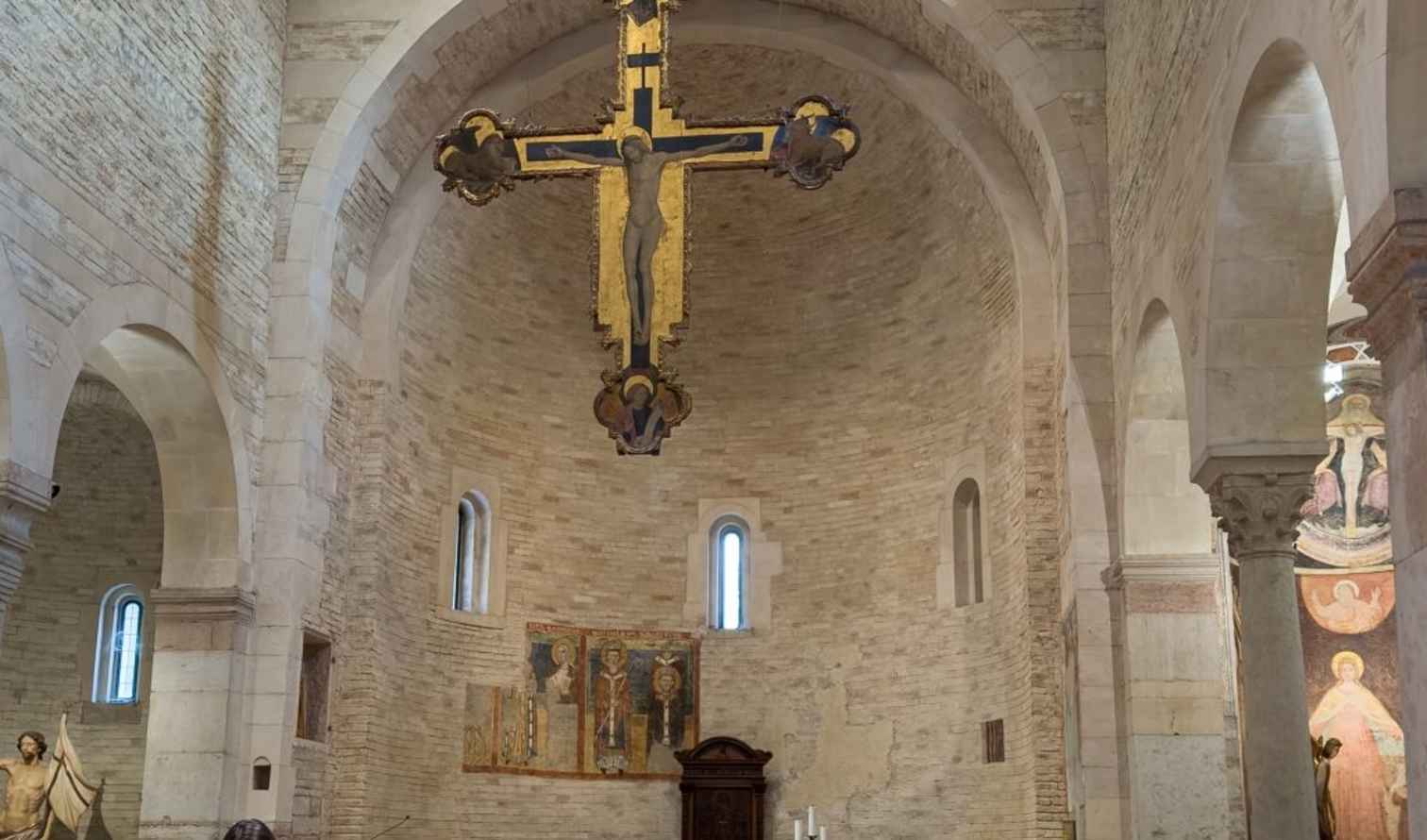 Stone arches and religious artworks inside San Damiano Church in Verona