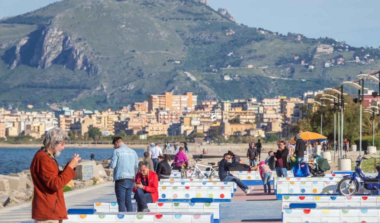 Families and individuals enjoying the seaside walk in Palermo, Sicily.