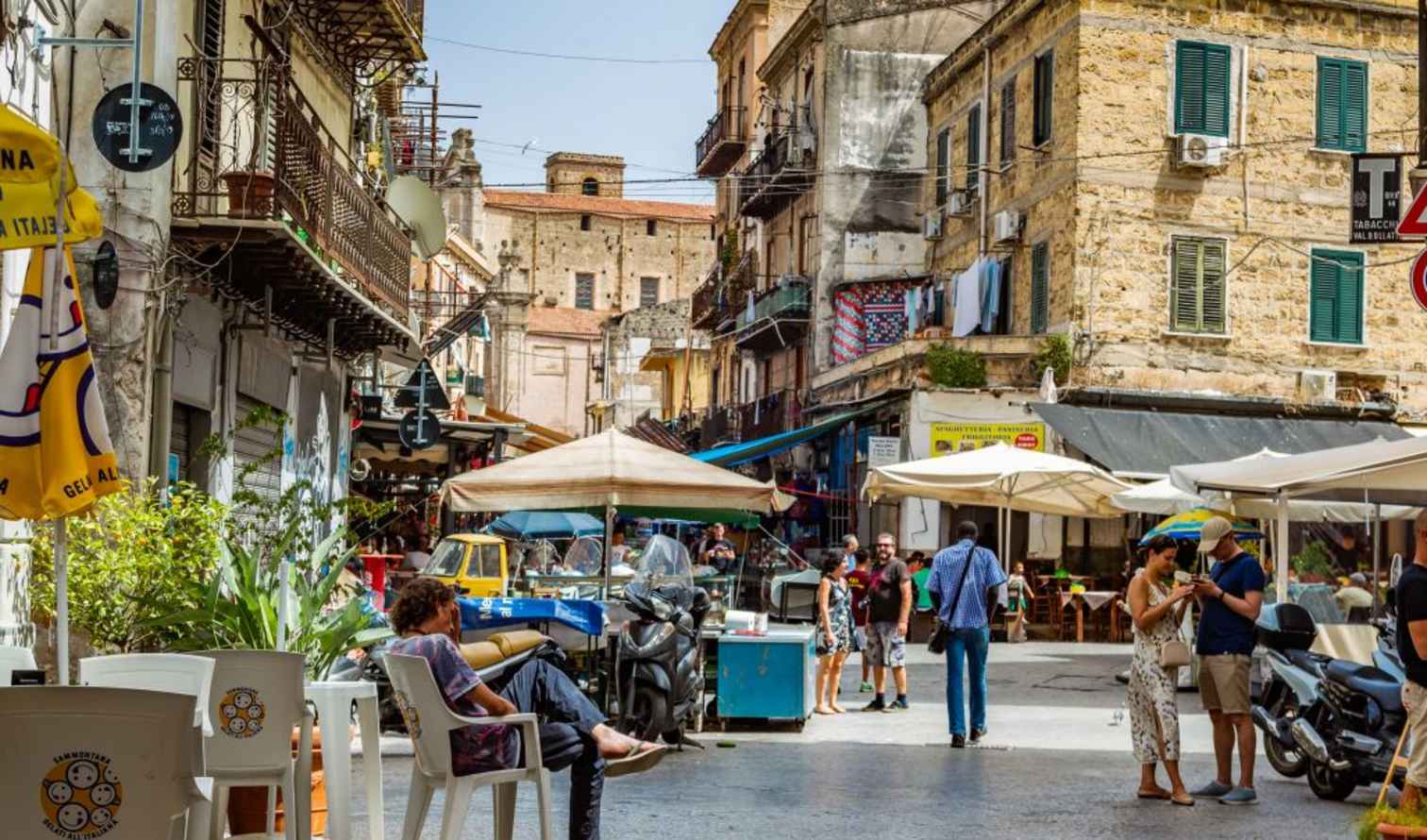 Street scene in Ballarò Market, Palermo, showing vendors and shoppers.