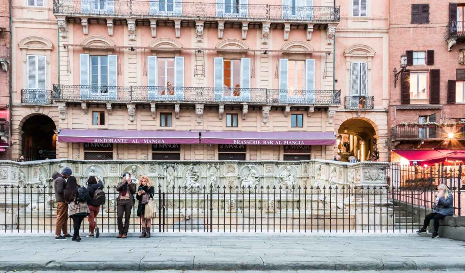Piazza del Campo with Fonte Gaia fountain and historic buildings in Siena.