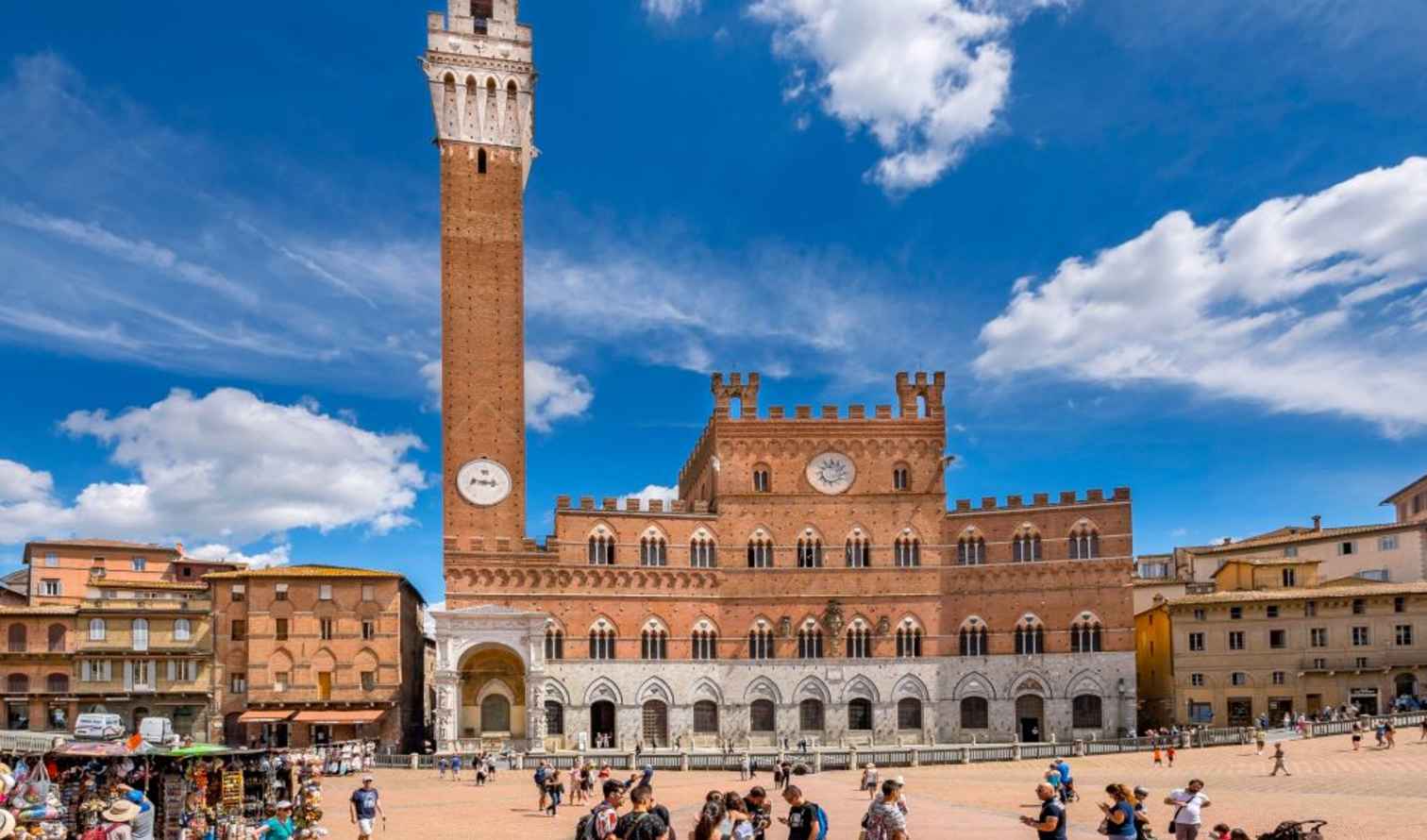 People walking in front of the Palazzo Pubblico in Piazza del Campo, Siena.