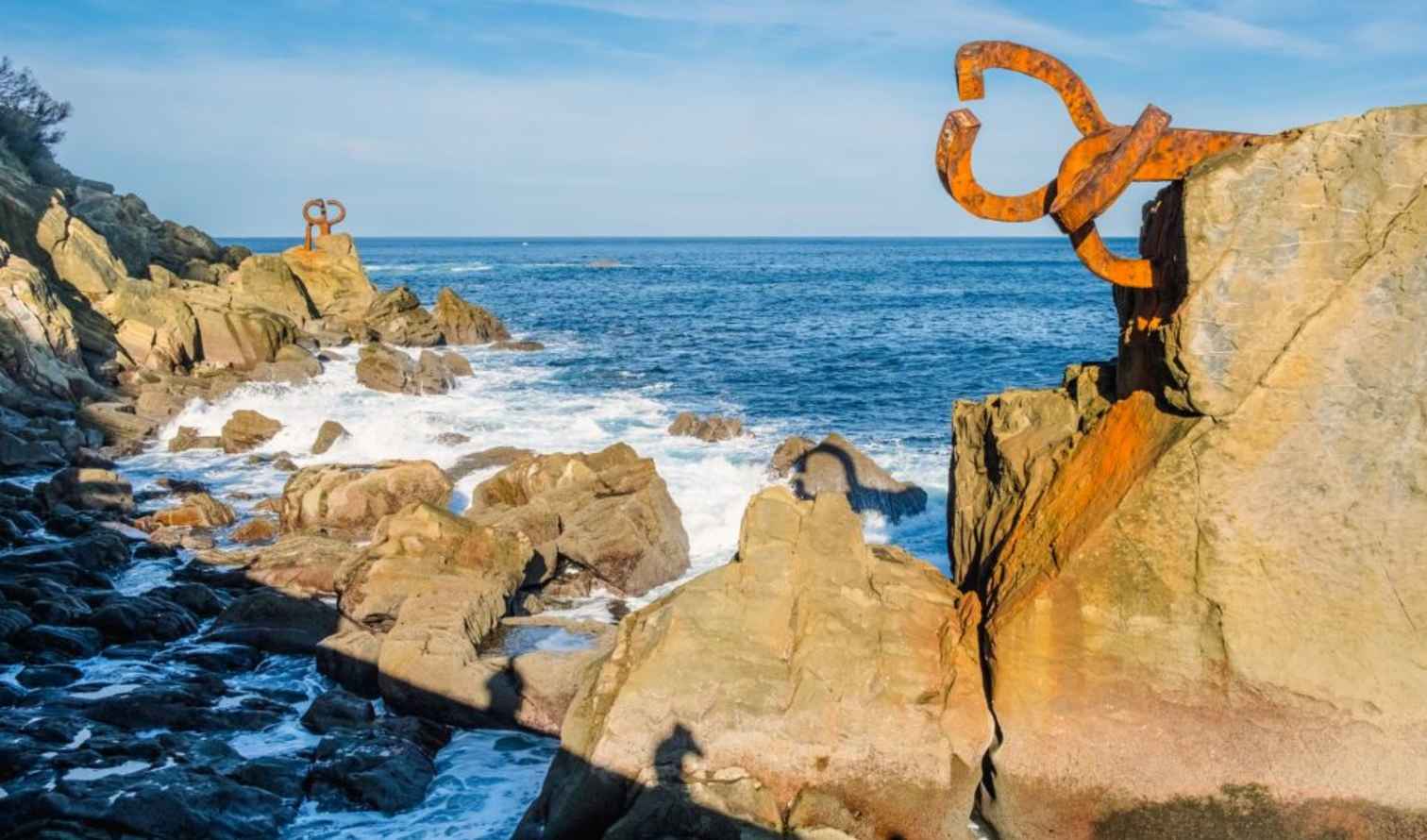 Rusty sculptures on rocks at Peine del Viento in San Sebastián, Spain.