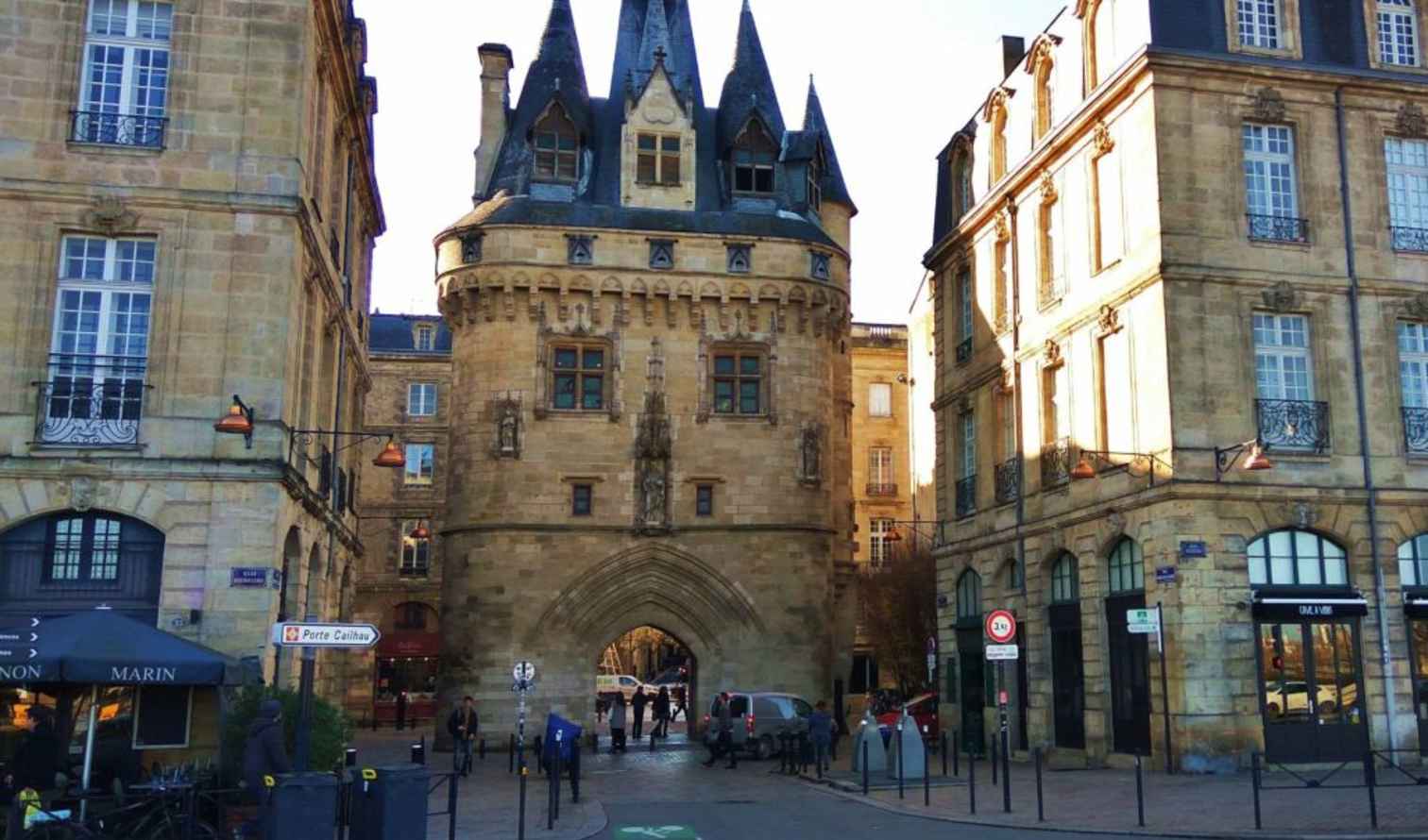 Porte Cailhau in Bordeaux with historic buildings on either side.